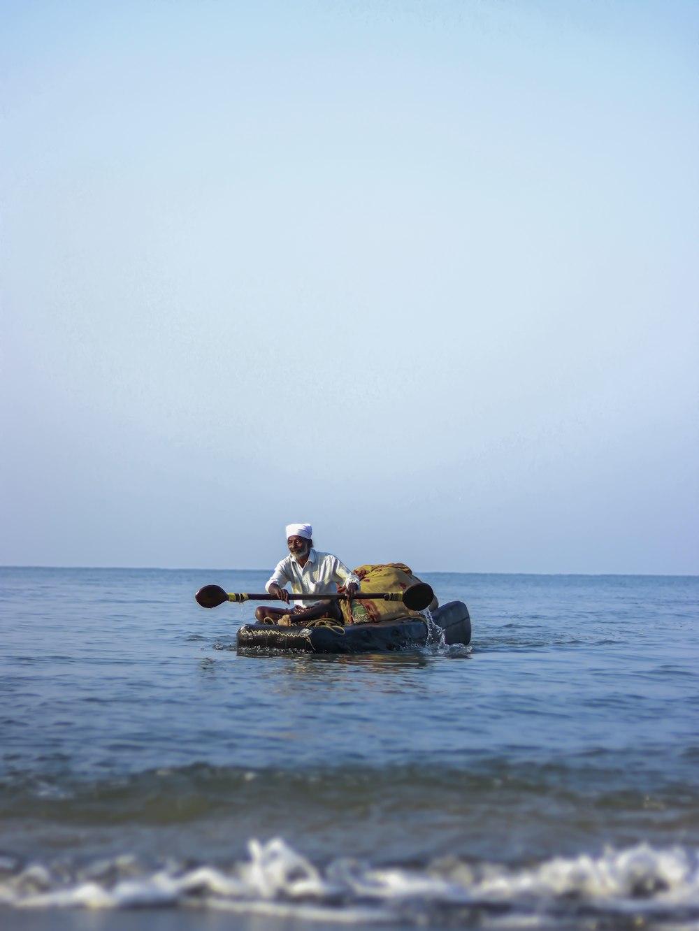 a man is paddling a canoe in the ocean