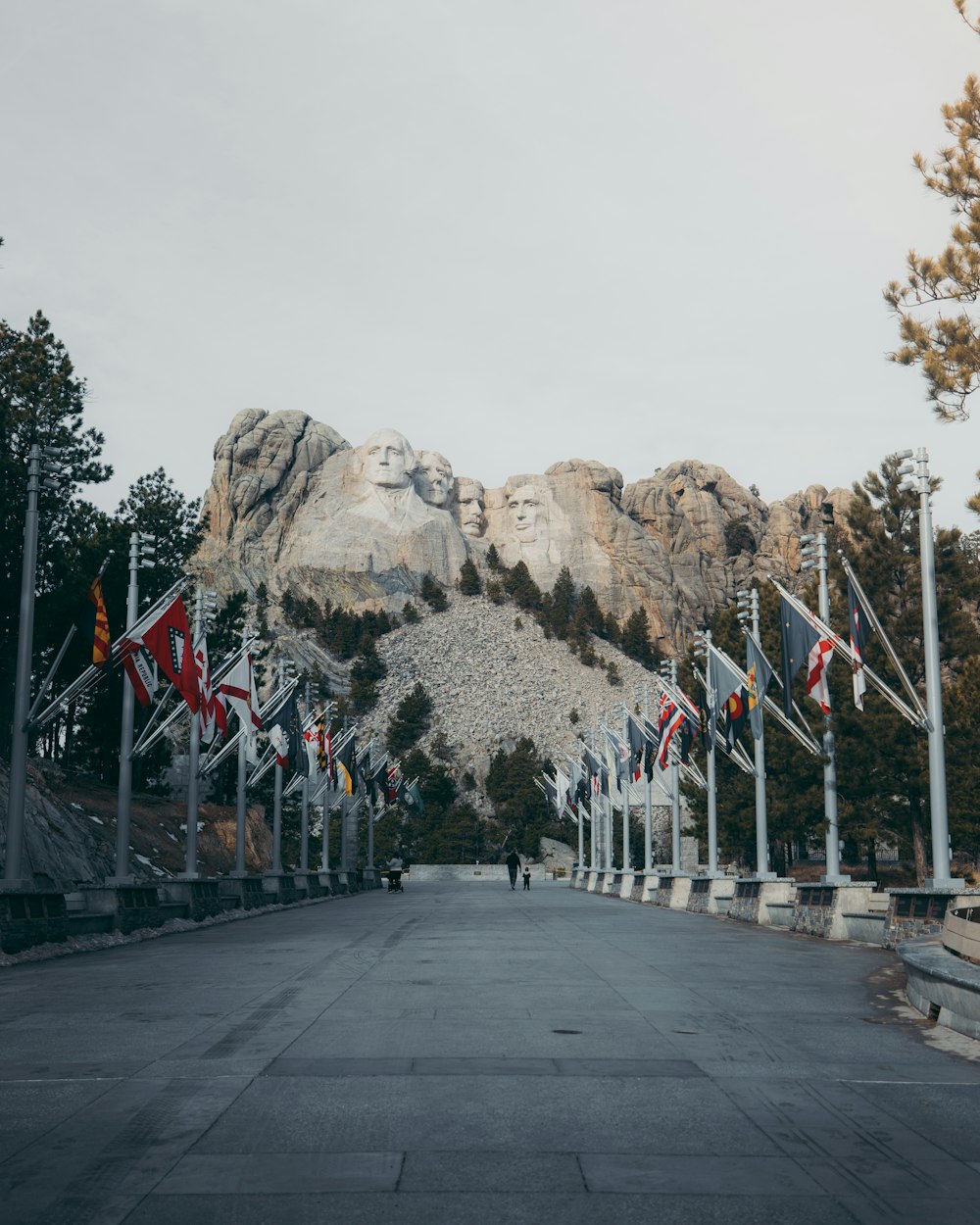 a road with flags and mountains in the background