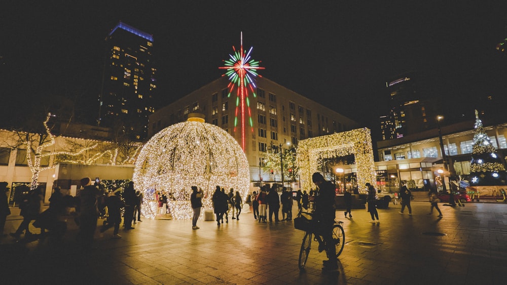 a group of people standing around a christmas light display