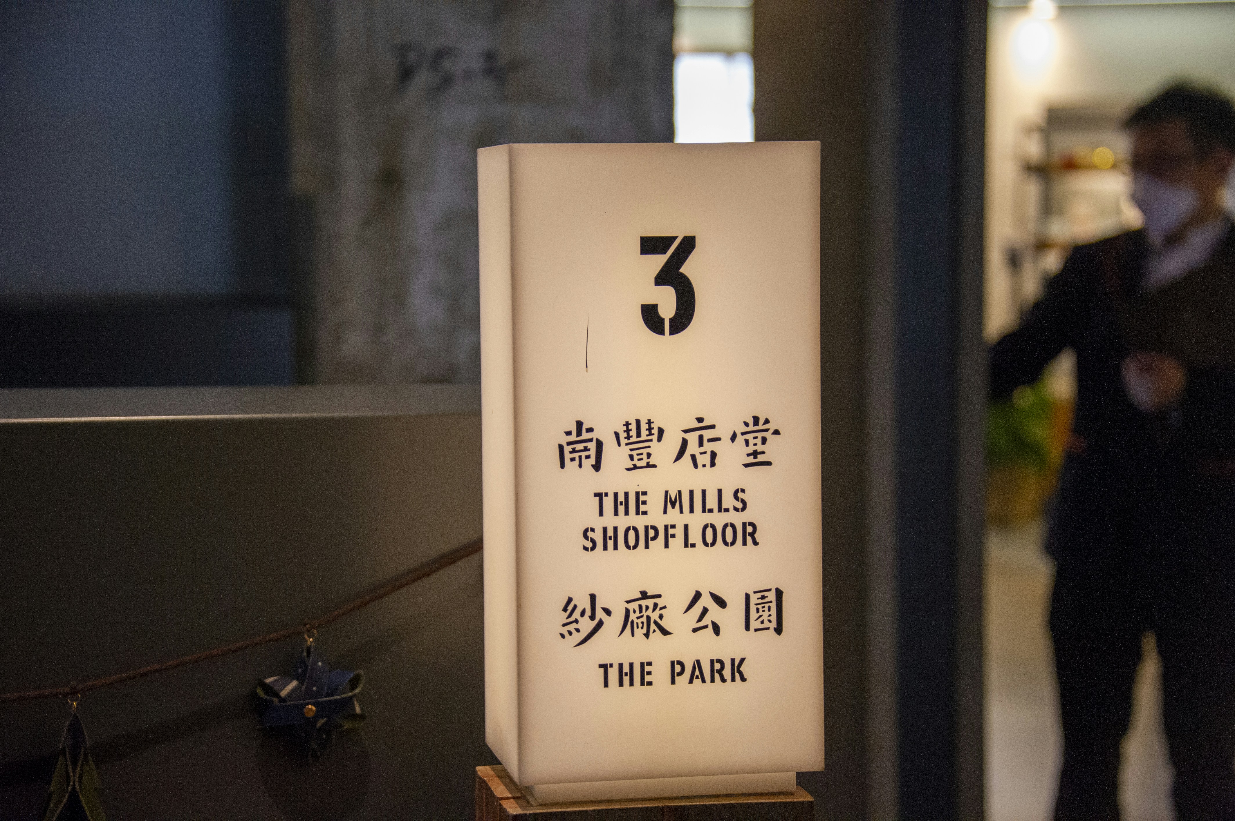 Un homme en costume debout à côté d’une pancarte