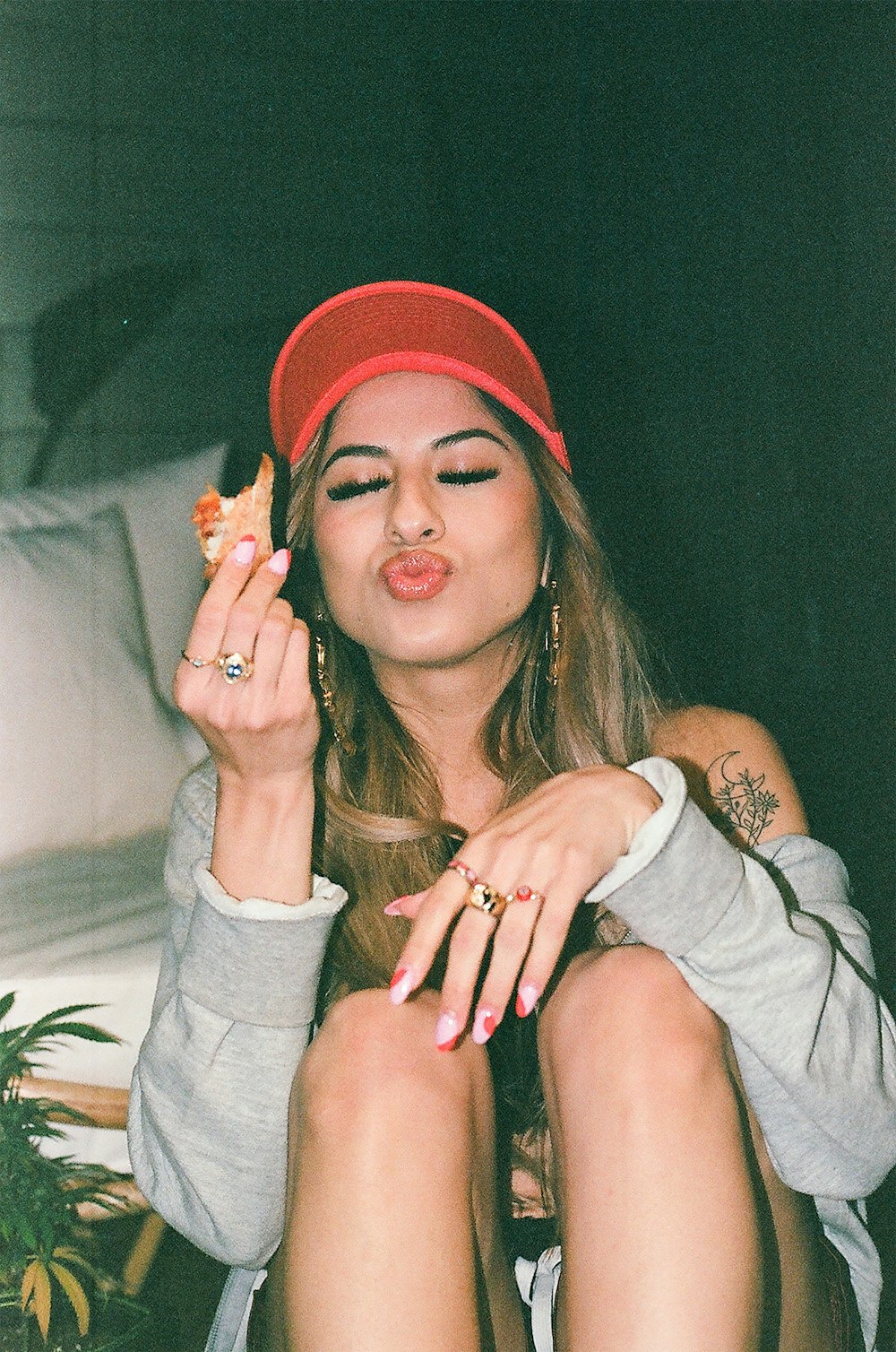 a woman sitting on a bed holding a piece of food