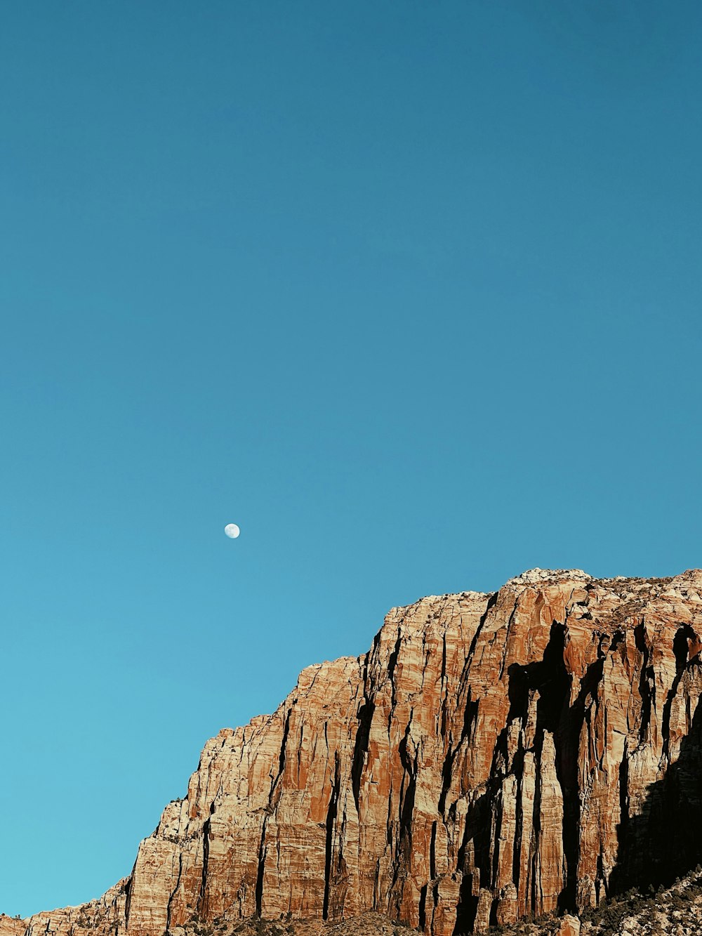 a mountain with a half moon in the sky