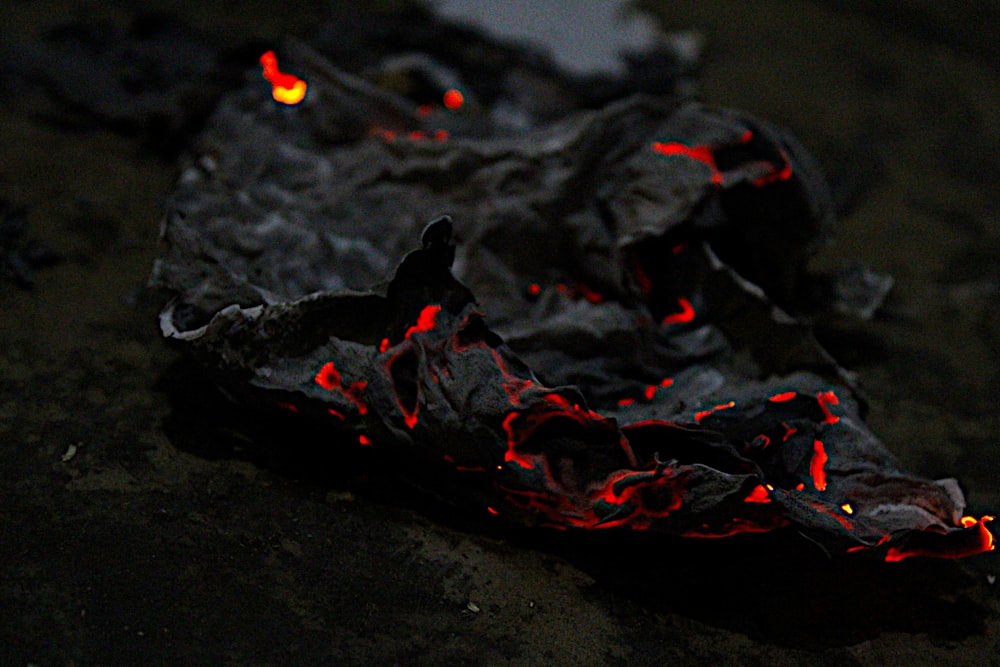 a piece of black material with red lava on it