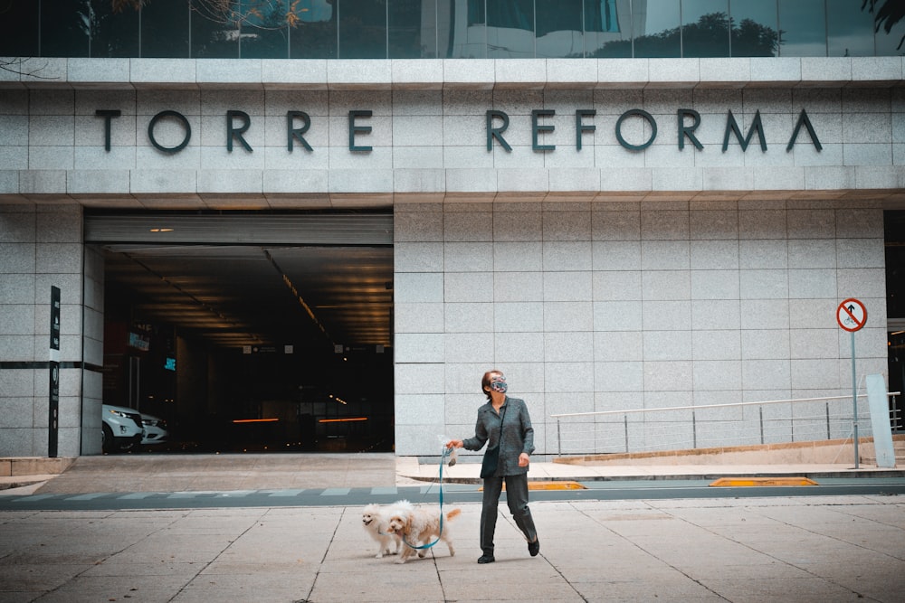 a man walking a dog in front of a building