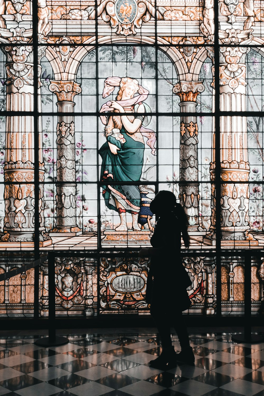 a person standing in front of a stained glass window