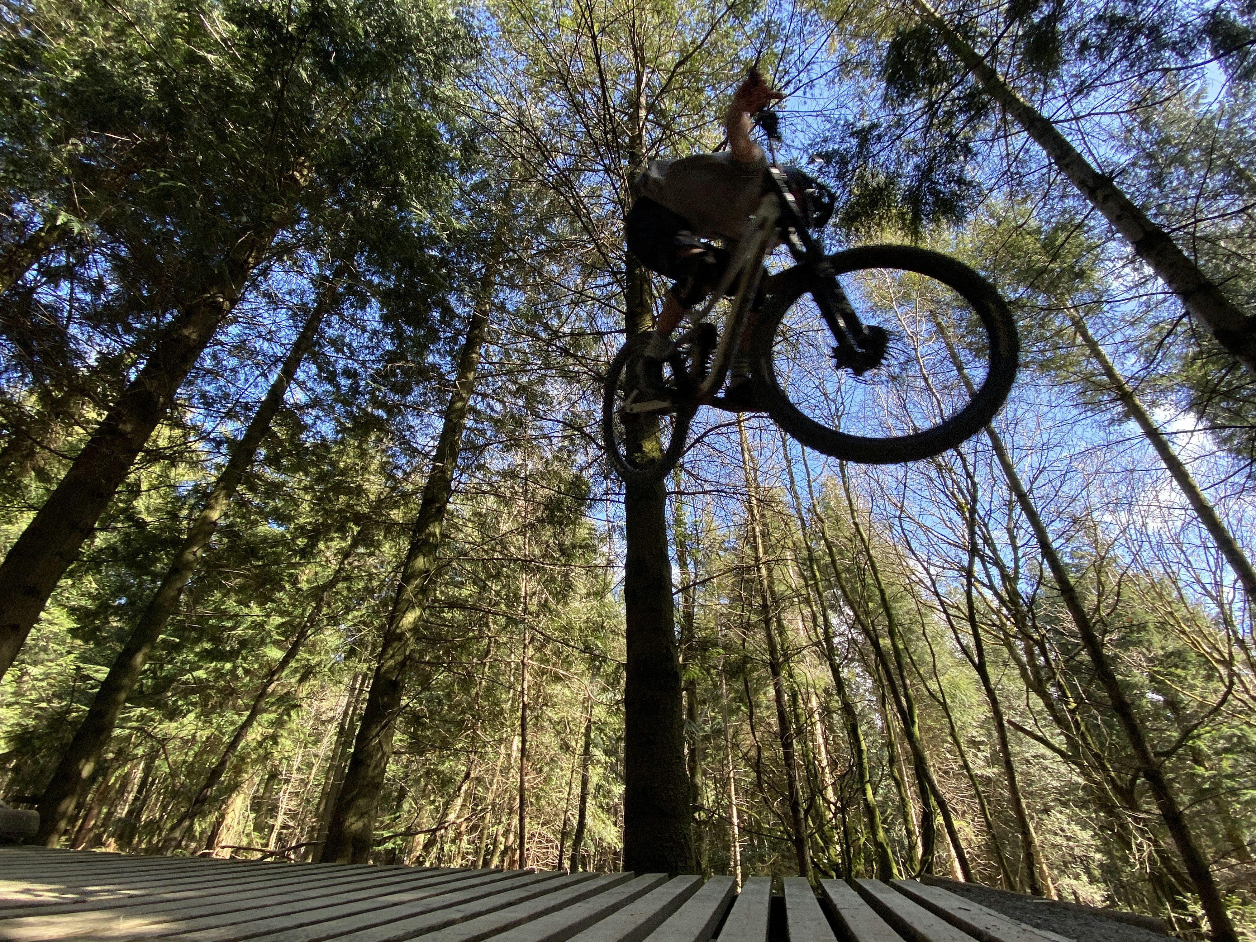 a person jumping a bike over a wooden platform