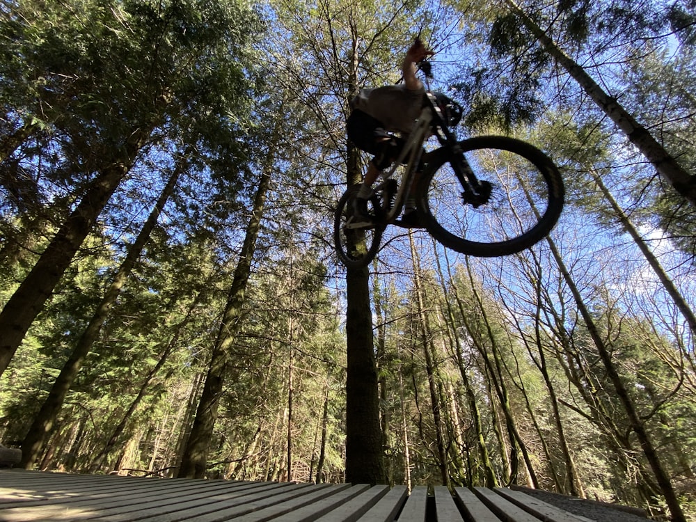 a person jumping a bike over a wooden platform