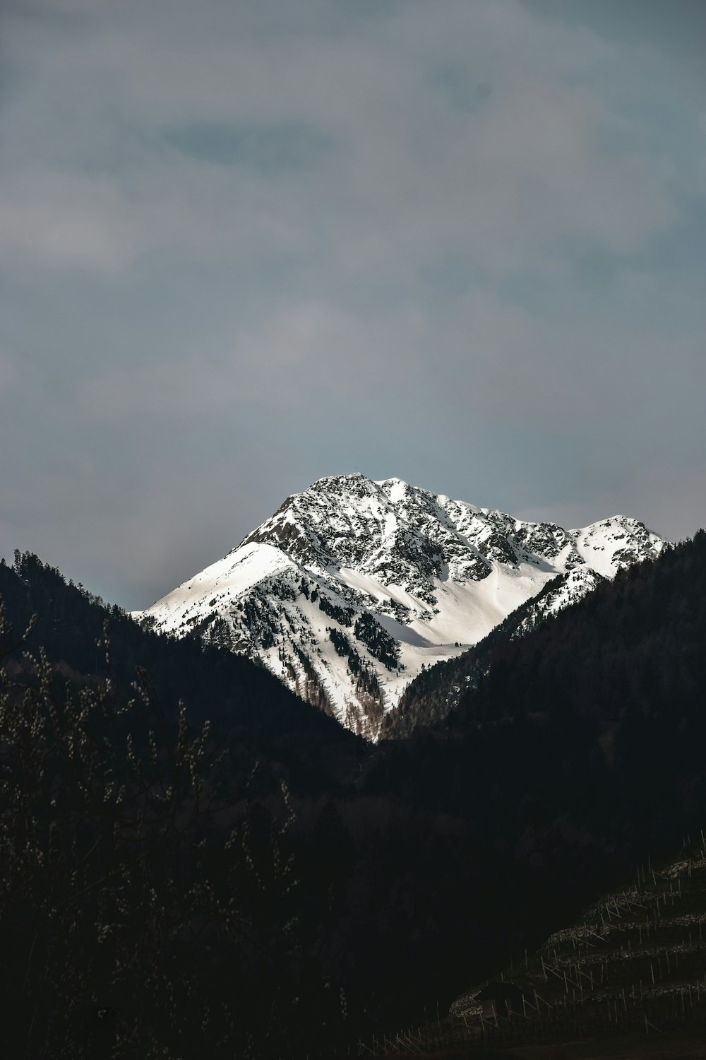 a mountain covered in snow under a cloudy sky