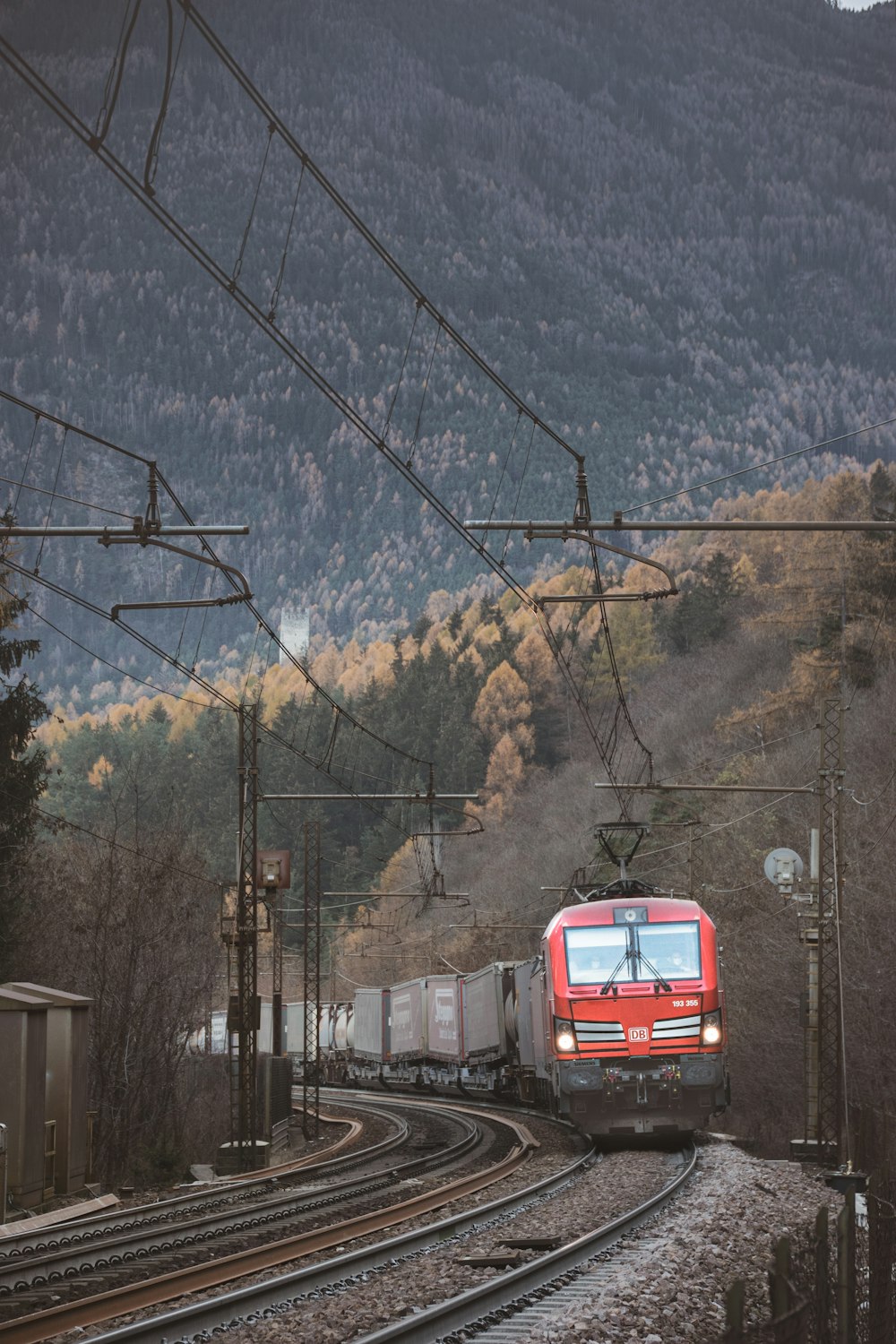 Ein Zug, der neben einem Berg die Bahngleise hinunterfährt