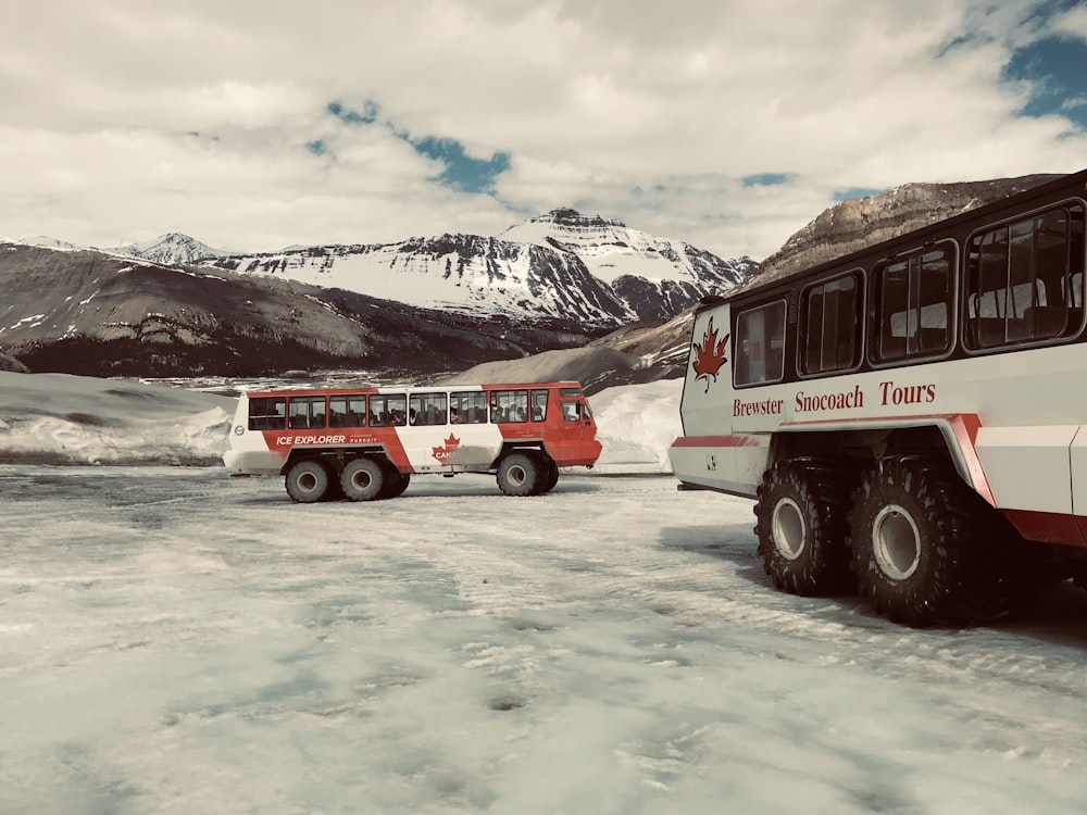 a red and white bus parked in the snow
