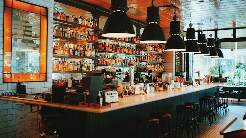 Rows of liquor and tequila bottles lined up behind a restaurant bar, similar to the tequila list La Neta was known for