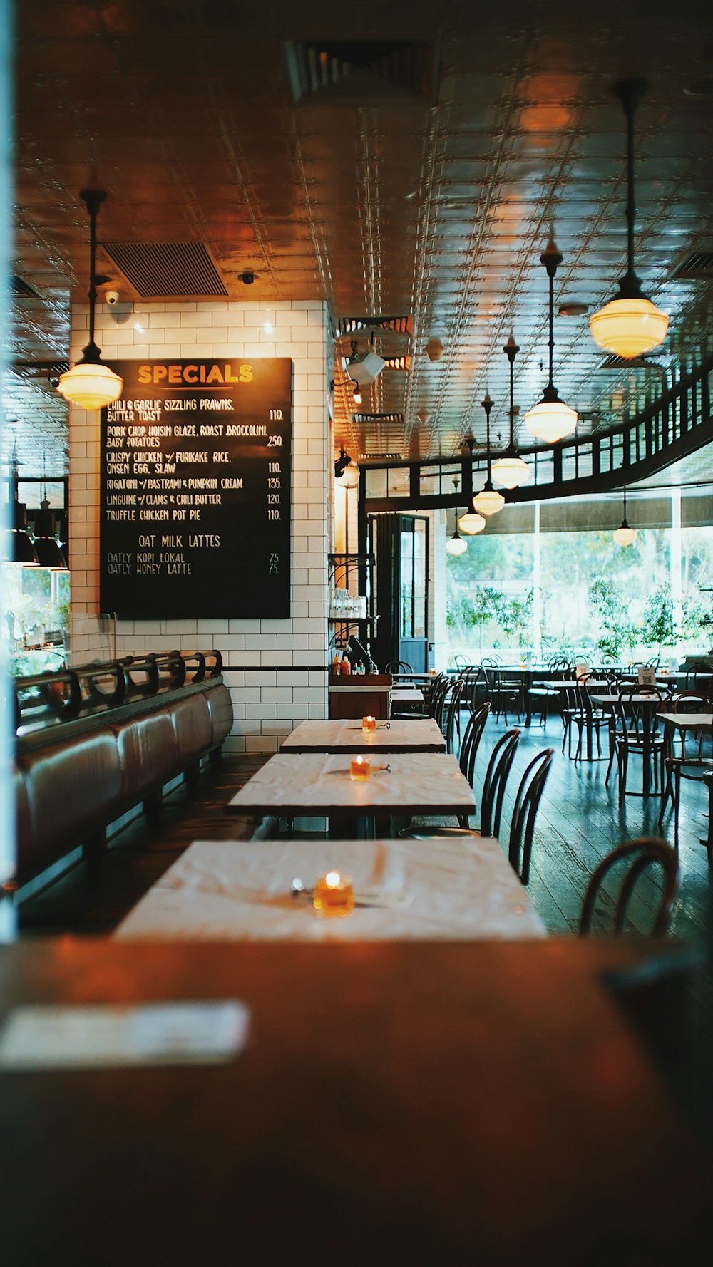 a restaurant with tables and chairs and a menu on the wall