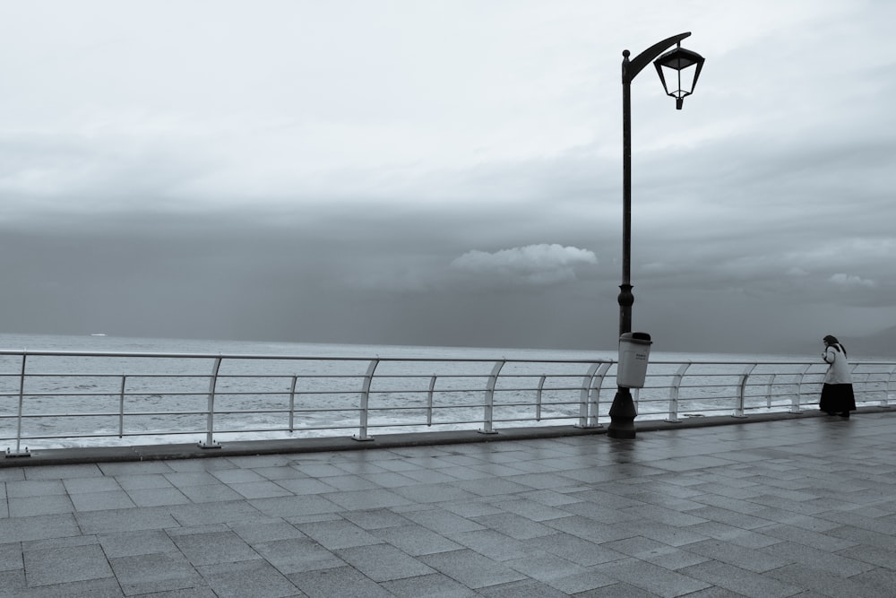 a person standing on a pier next to the ocean