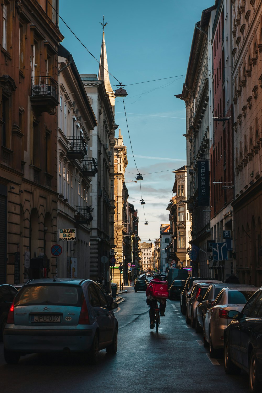 a man riding a bike down a street next to tall buildings