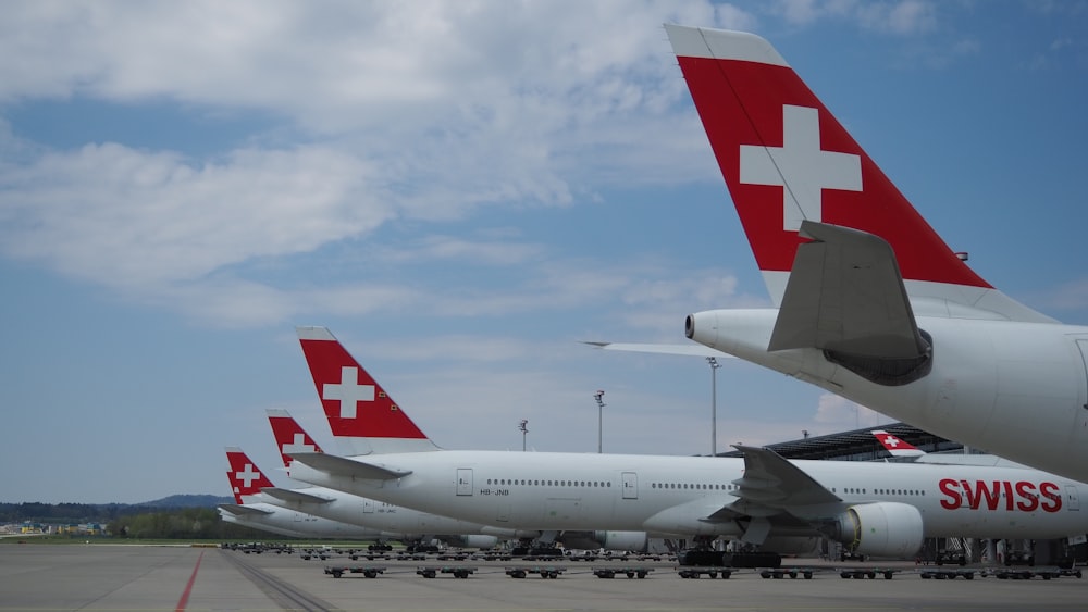 a row of airplanes sitting on top of an airport tarmac