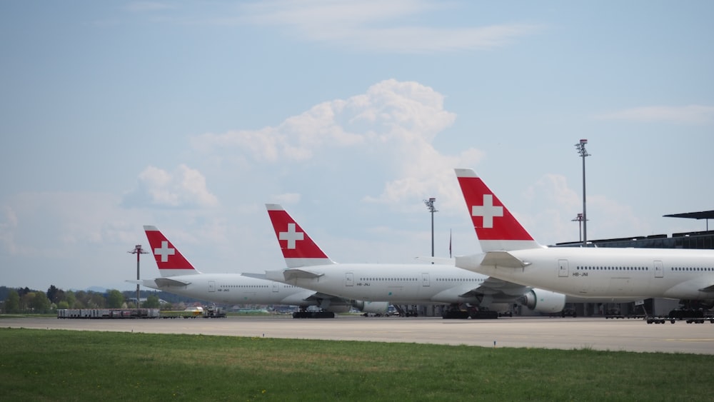 a row of airplanes sitting on top of an airport tarmac