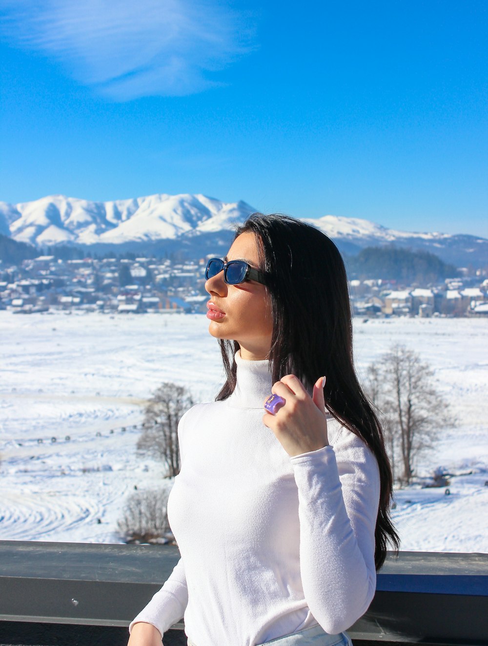 a woman wearing sunglasses and a white shirt