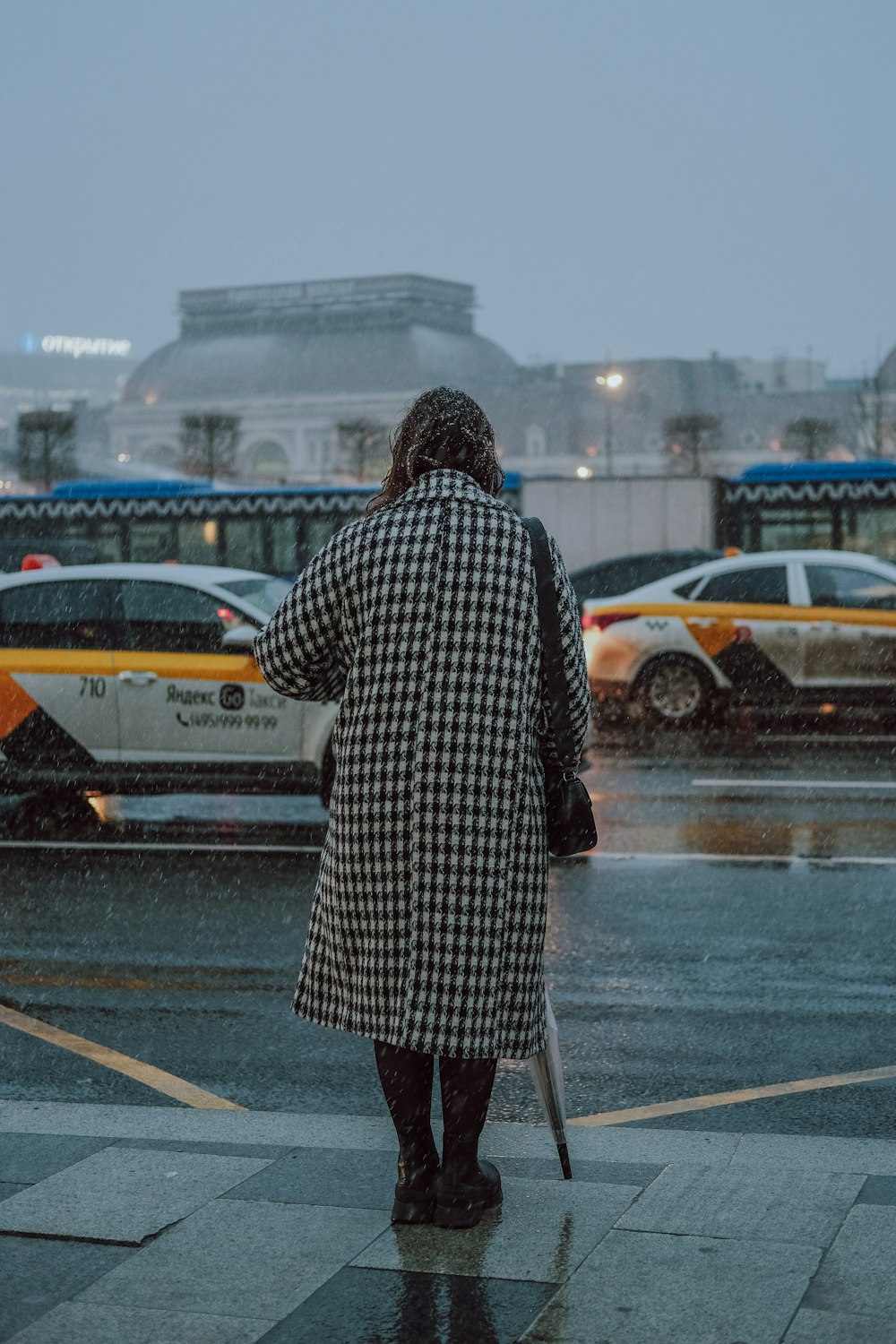 a woman standing in the rain with an umbrella