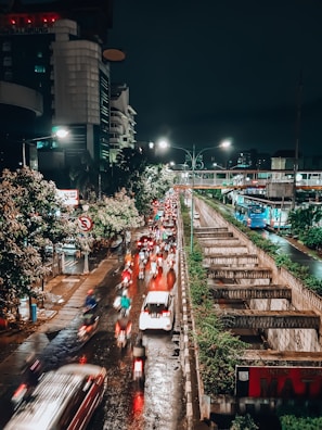 Night-time shot of a busy urban street with cars and bikes seamlessly integrated via smart technology.