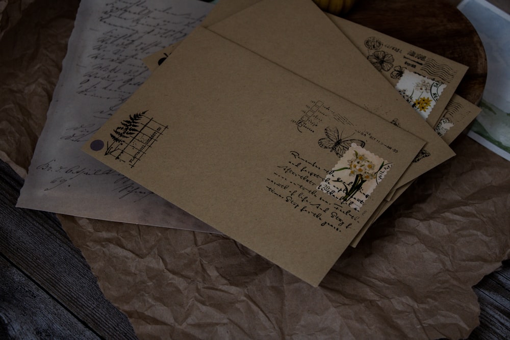 a pile of envelopes sitting on top of a wooden table