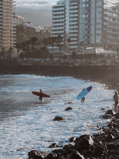 a couple of people with surfboards in the water