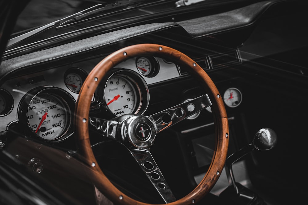 a car dashboard with a steering wheel and gauges