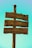 A wooden signpost with three directional arrows carved into the wood, indicating distances to different locations: Jerusalén, Santiago de Compostela, and Santo Toribio de Liébana. The wood appears aged and weathered, and each sign has a red cross emblem.