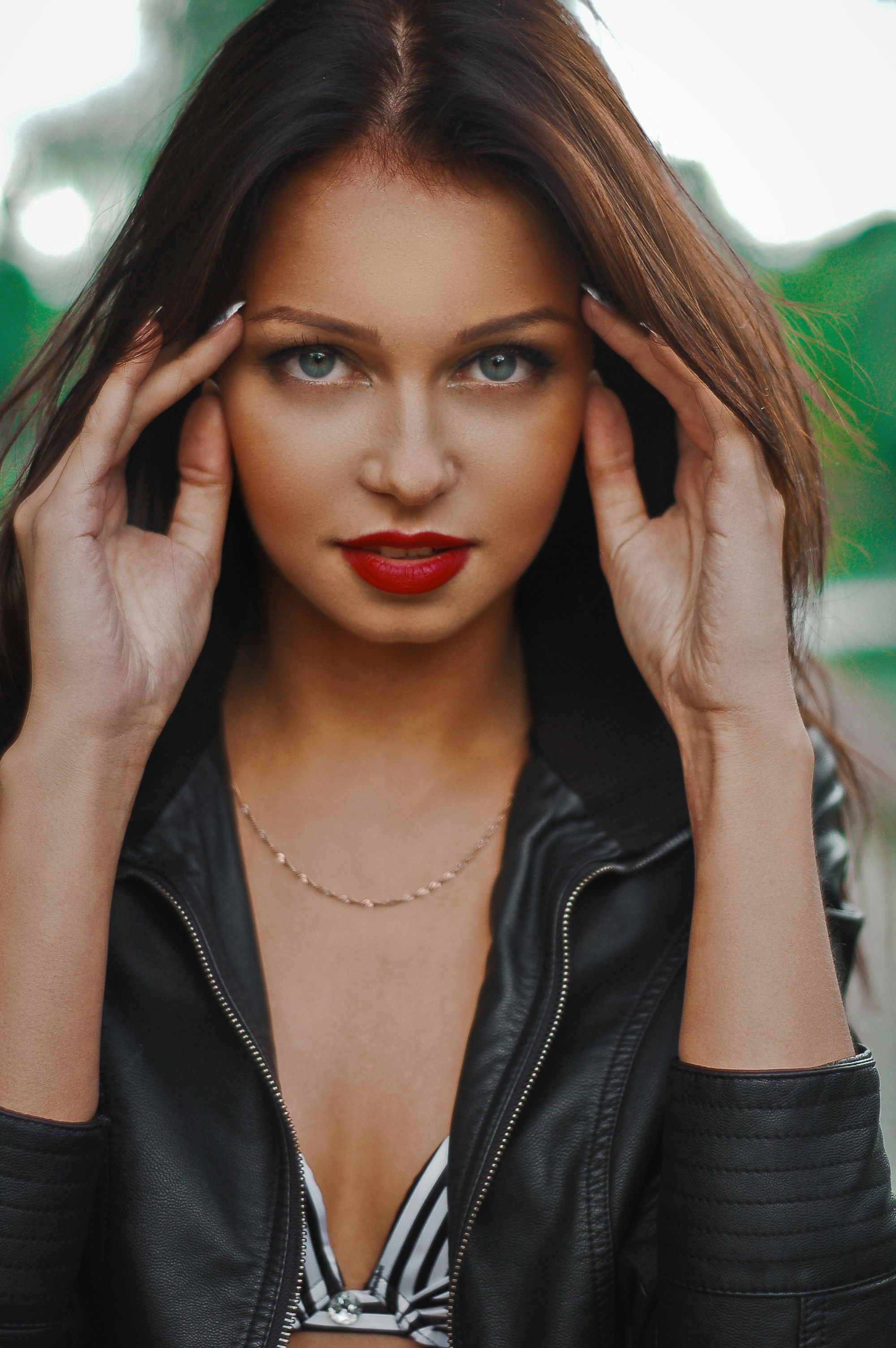 a woman with red lipstick and a black leather jacket