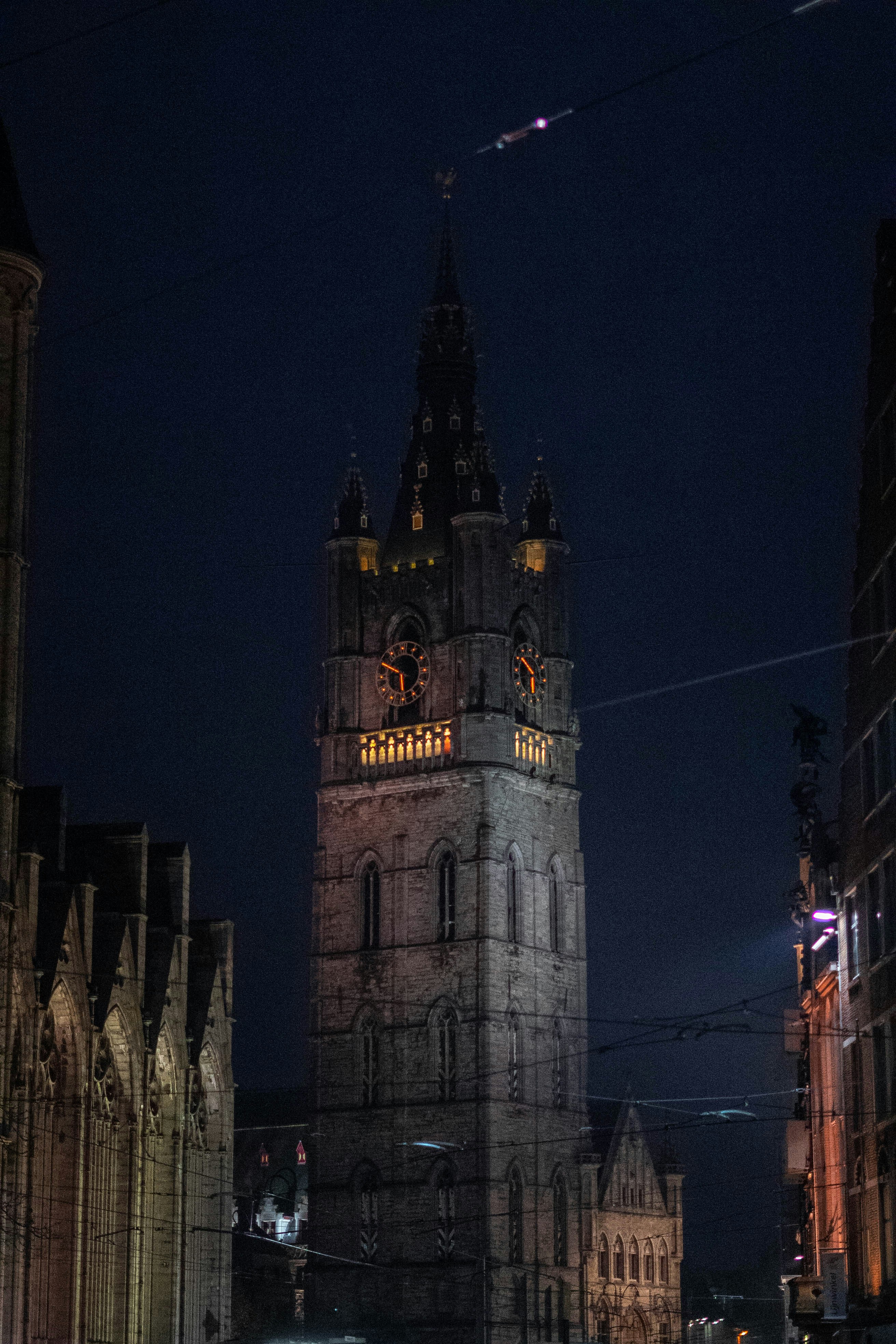 A large clock tower towering over a city at night photo – Free Gent ...