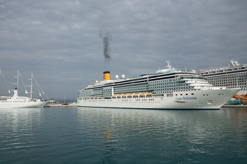 a cruise ship in a harbor with other ships in the background