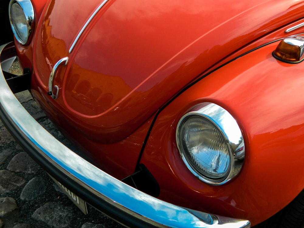 a close up of the front end of a red vw bug