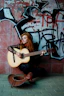 a woman sitting on the ground with a guitar