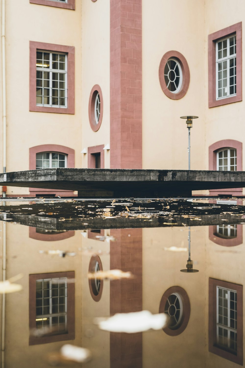 a reflection of a building in a puddle of water