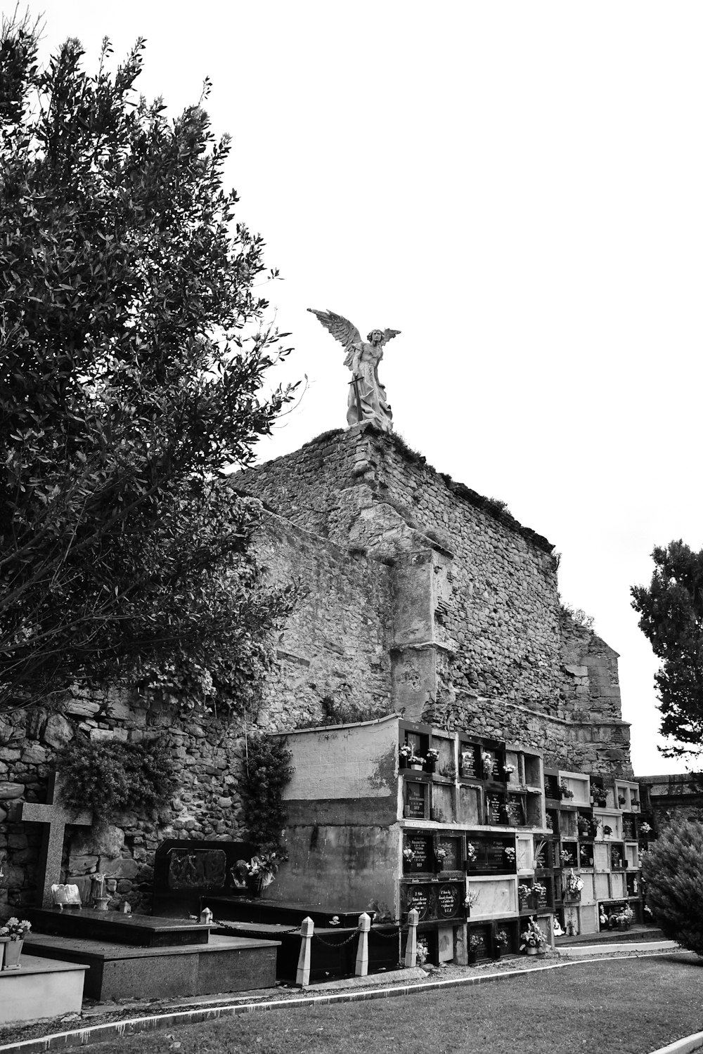 a black and white photo of a building with a statue on top of it