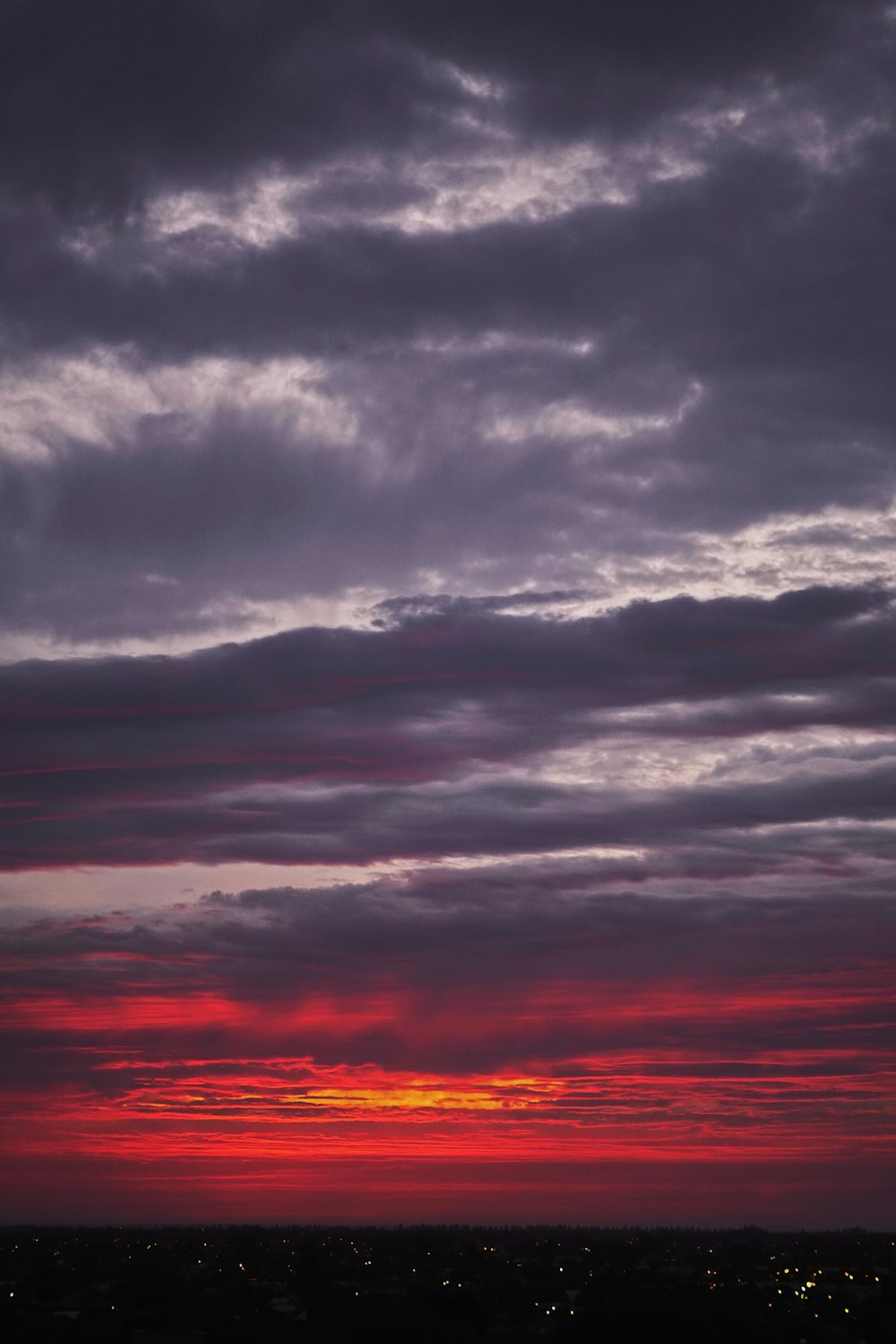 a red and purple sky with some clouds