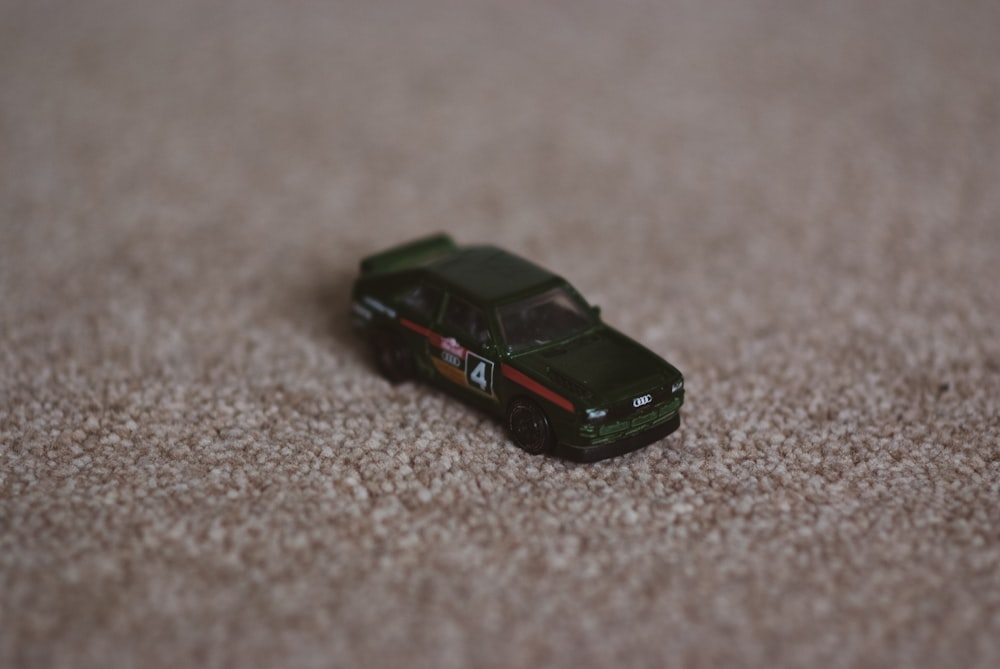 a toy car sitting on a carpeted floor