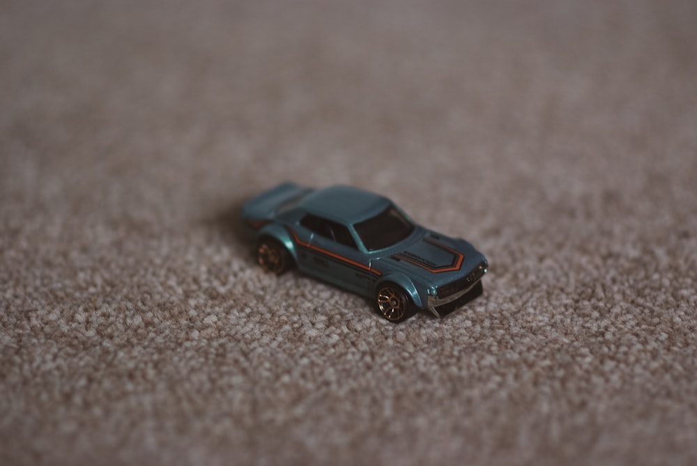 Una macchinina giocattolo seduta su un pavimento di moquette