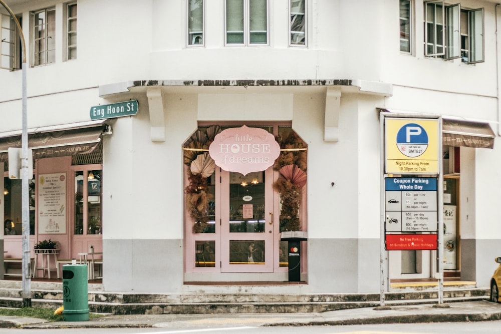 a white building with a pink sign in front of it