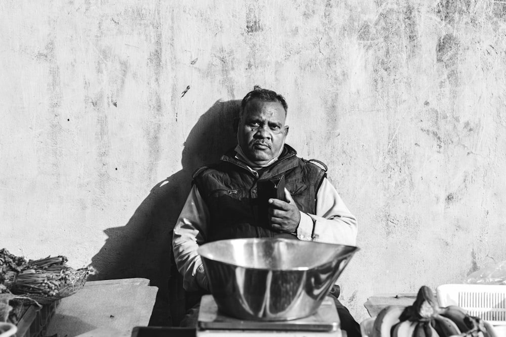 a black and white photo of a man holding a bowl