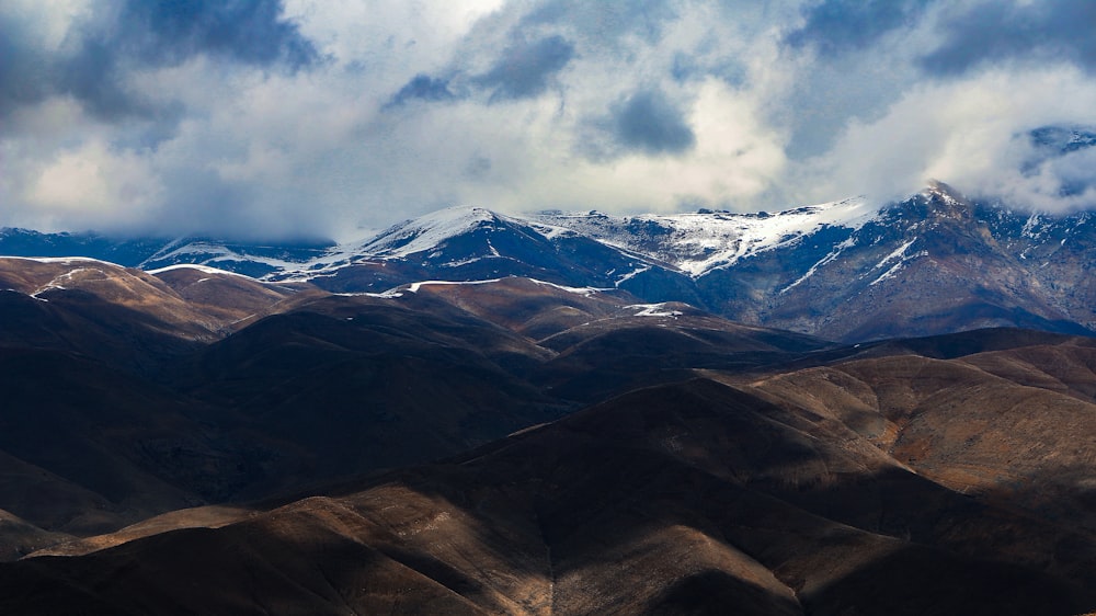 a mountain range with snow capped mountains in the background