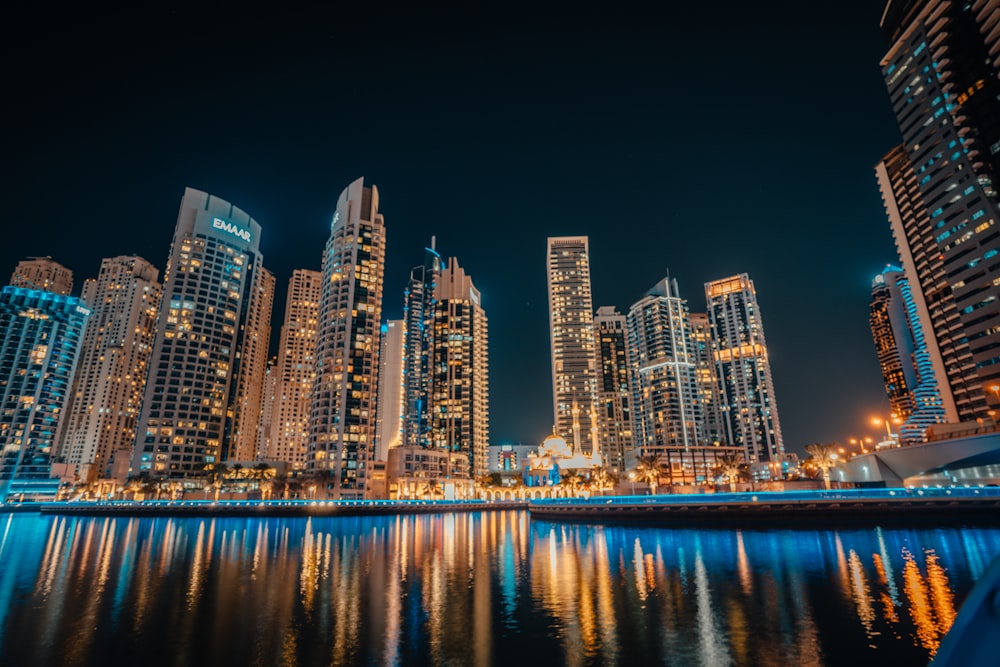 a city at night with lights reflecting in the water