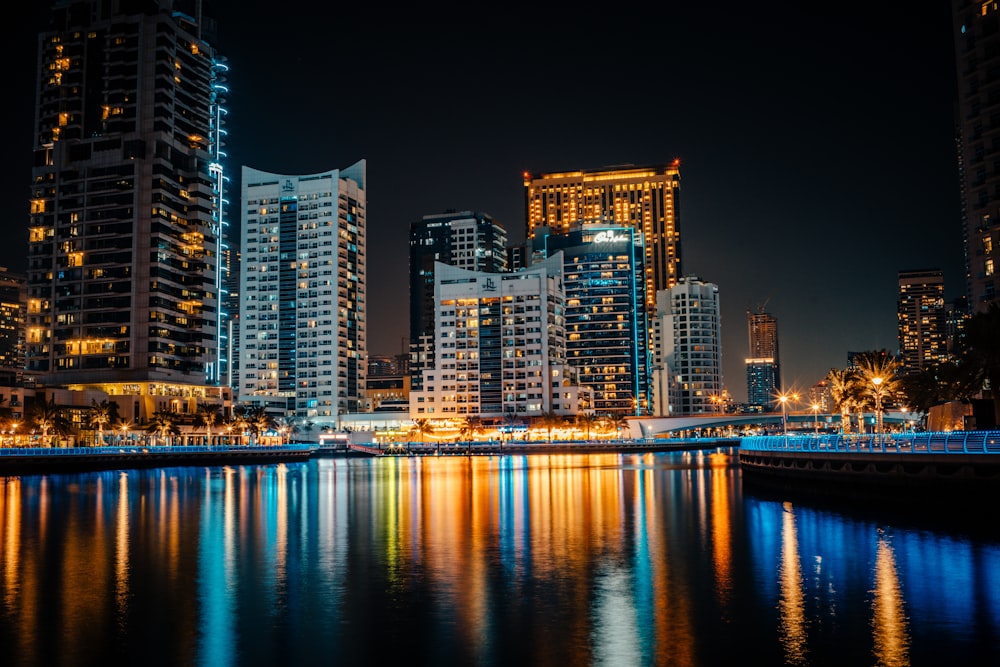 a city at night reflected in a body of water