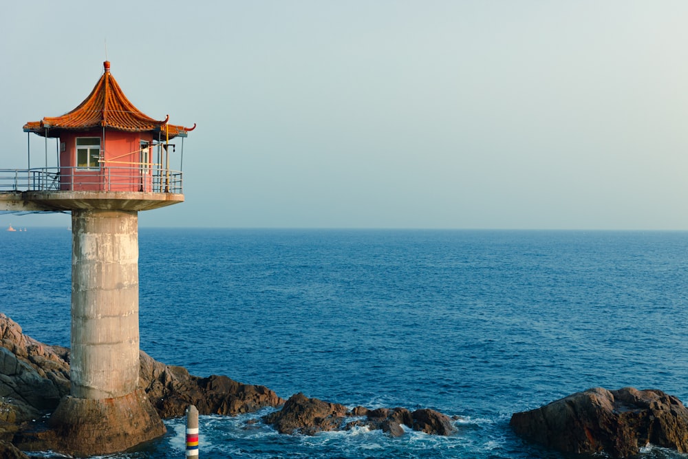 a light house sitting on top of a cliff next to the ocean
