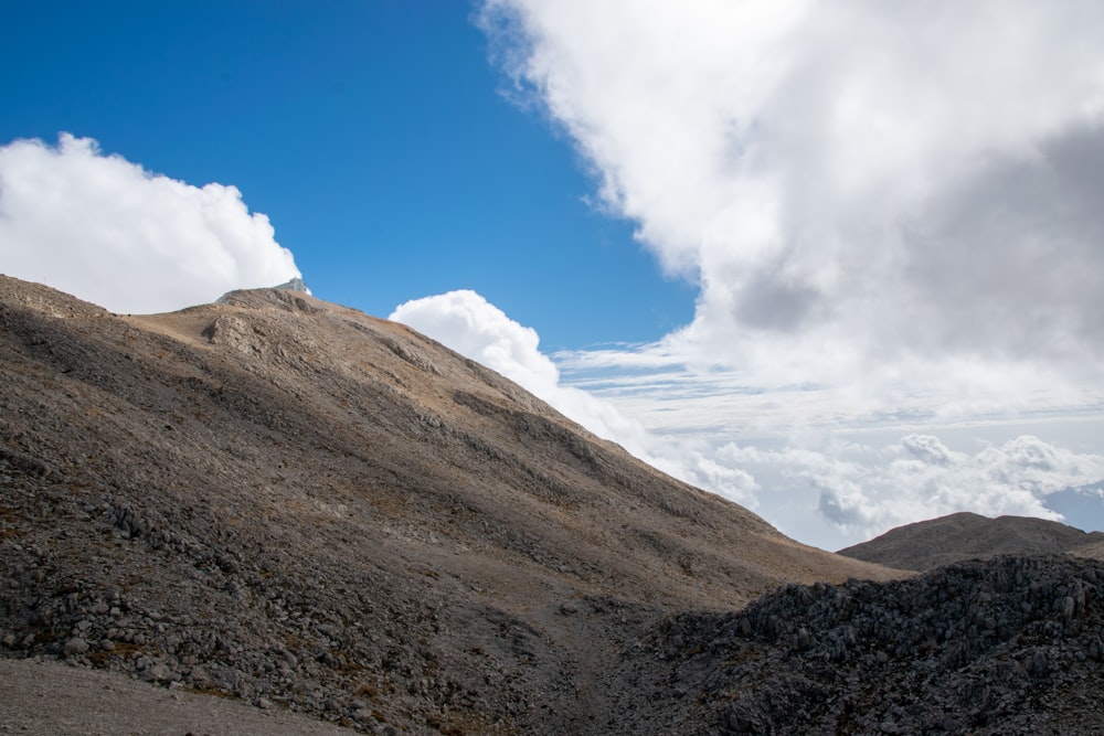 a view of the top of a mountain with clouds in the sky