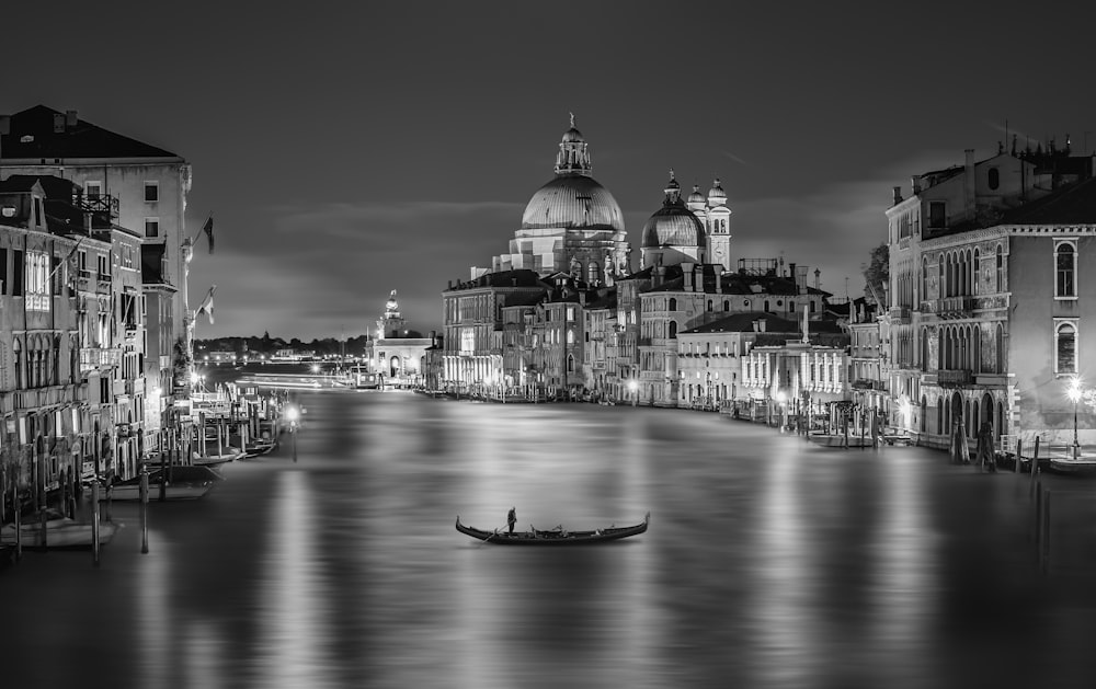 a black and white photo of a boat in a canal