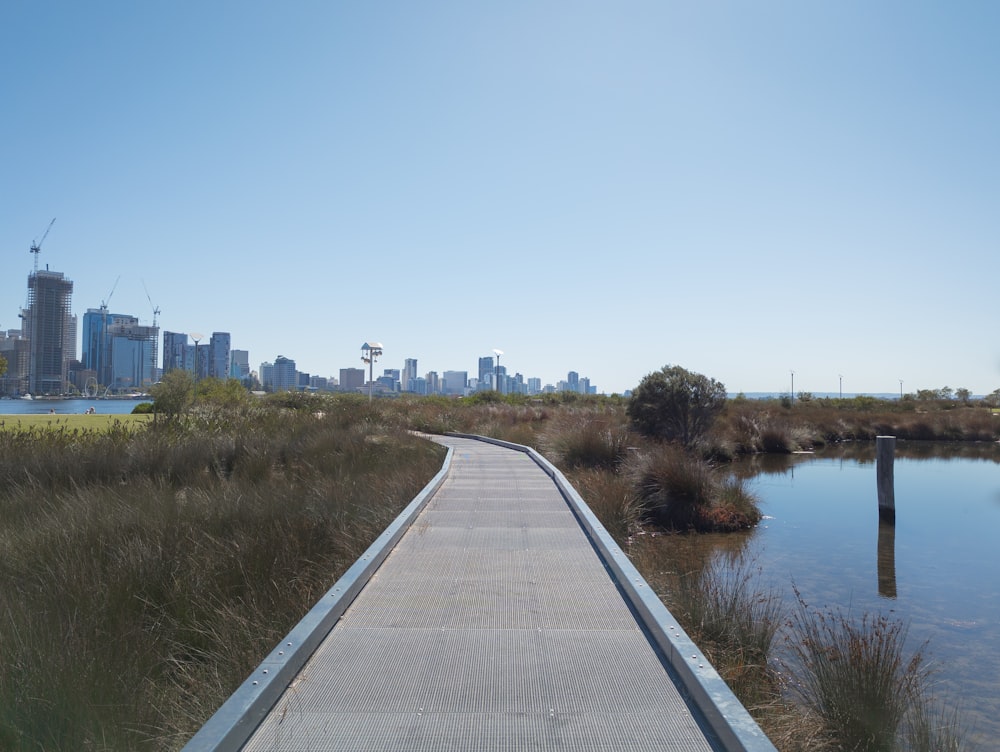 Una passerella che conduce a uno specchio d'acqua con una città sullo sfondo