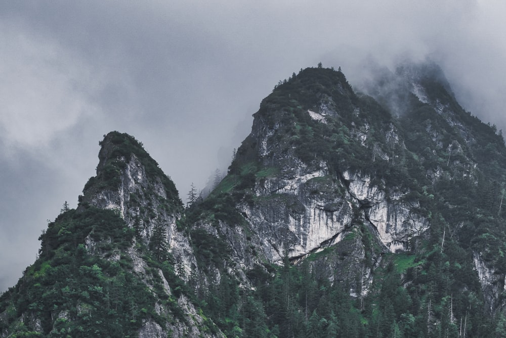 a mountain covered in fog and clouds on a cloudy day