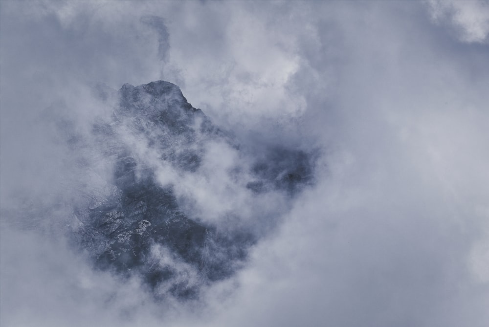 a mountain covered in clouds in the middle of the day
