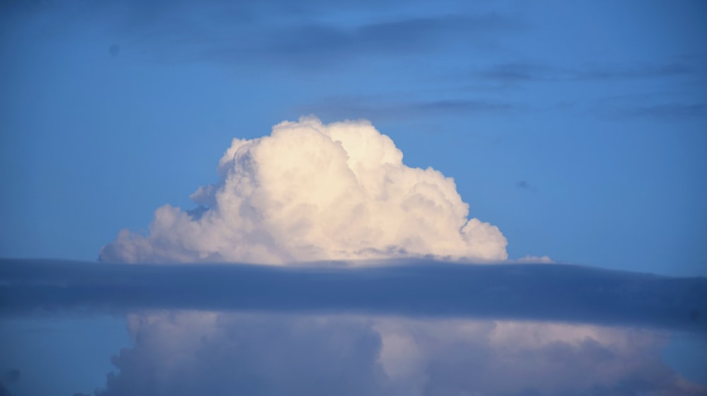 a large cloud in the middle of a blue sky