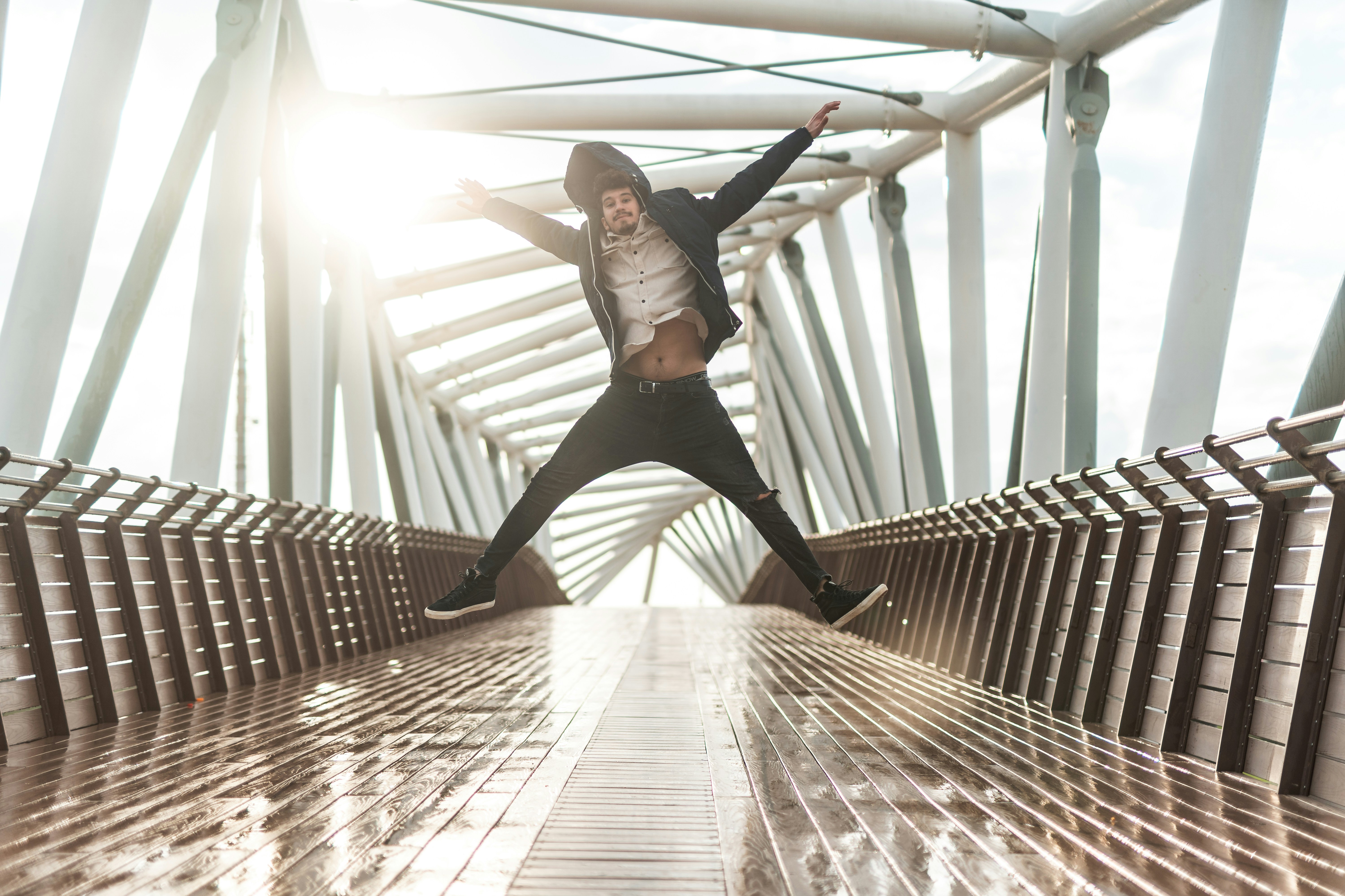 10 Easy Ways to Incorporate More Movement Into Your Workday – a man is jumping in the air on a bridge